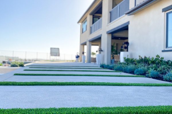 San Diego concrete driveway with synthetic turf bands at a Spanish-style home